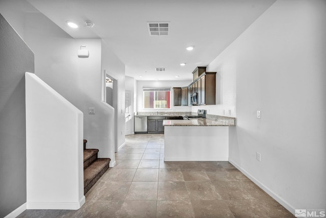 kitchen featuring kitchen peninsula, light stone counters, light tile patterned floors, sink, and stainless steel appliances