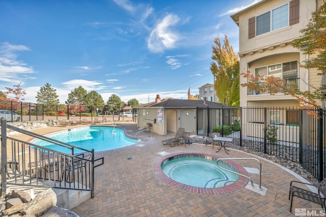 view of pool featuring a hot tub and a patio