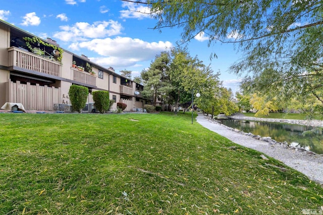 view of yard with a balcony and a water view