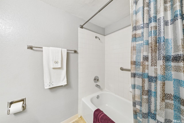 bathroom featuring a textured ceiling and shower / tub combo with curtain