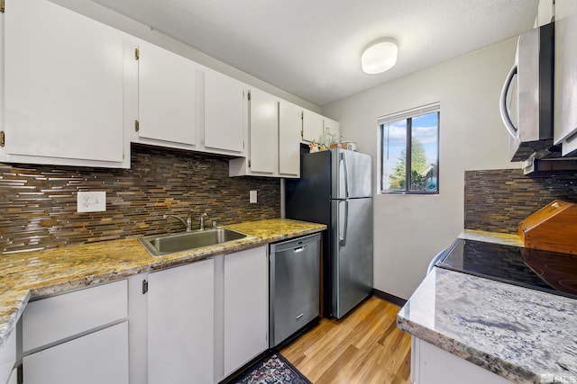 kitchen featuring sink, appliances with stainless steel finishes, white cabinetry, and tasteful backsplash