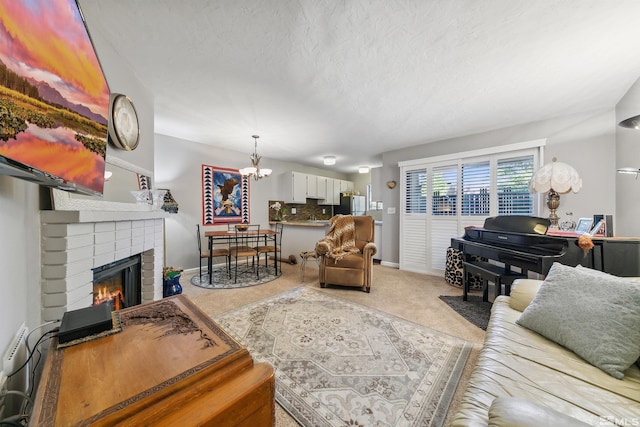 living room featuring a notable chandelier, a textured ceiling, a brick fireplace, and carpet flooring