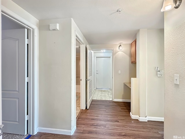 corridor with dark hardwood / wood-style flooring