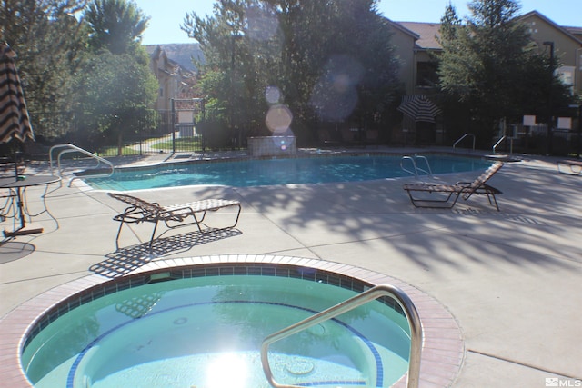 view of swimming pool with a patio area and a community hot tub