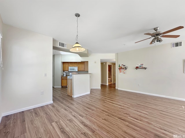 kitchen with ceiling fan, hanging light fixtures, and light hardwood / wood-style floors