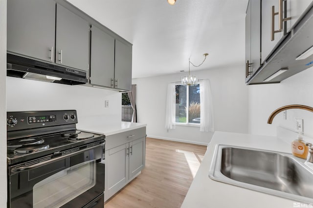 kitchen featuring hanging light fixtures, black electric range oven, sink, and gray cabinets