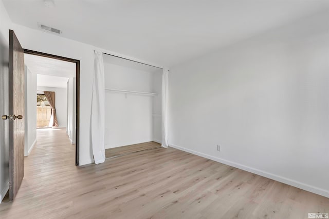 unfurnished bedroom with a closet and light hardwood / wood-style flooring