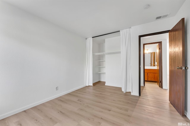 unfurnished bedroom featuring a closet and light hardwood / wood-style flooring