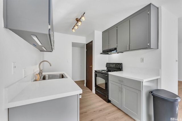 kitchen featuring light hardwood / wood-style flooring, black electric range oven, sink, and gray cabinetry