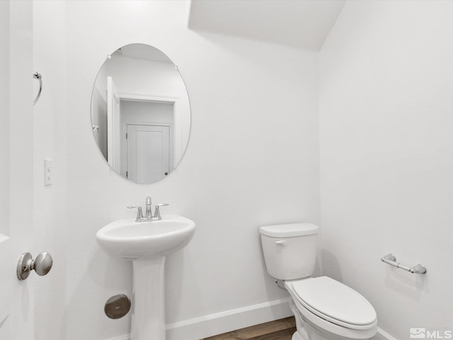 bathroom featuring toilet, hardwood / wood-style flooring, and sink