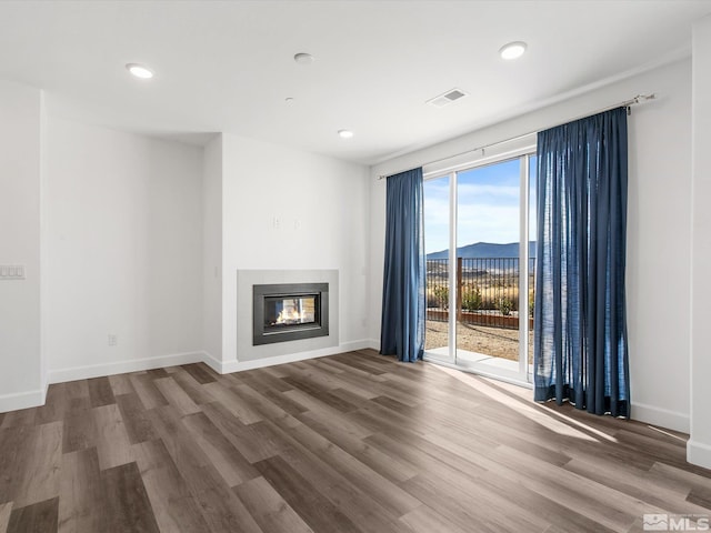 unfurnished living room with a mountain view and wood-type flooring