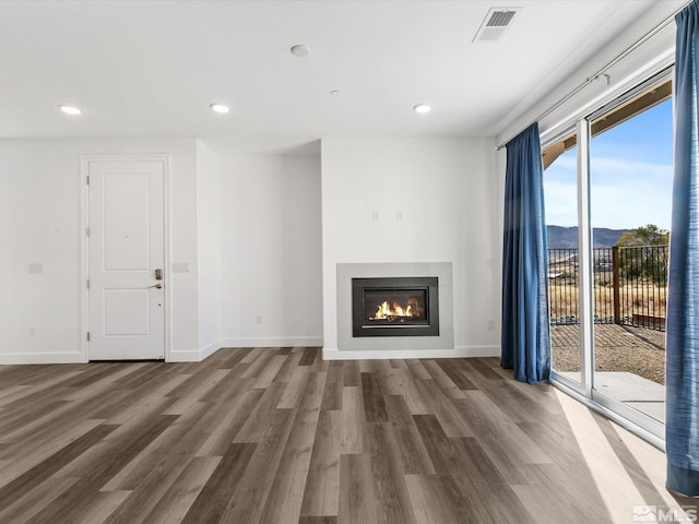 unfurnished living room with dark wood-type flooring and a mountain view