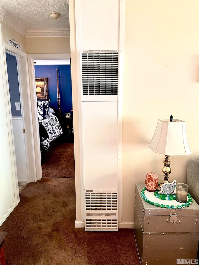 corridor with crown molding, a textured ceiling, and dark carpet