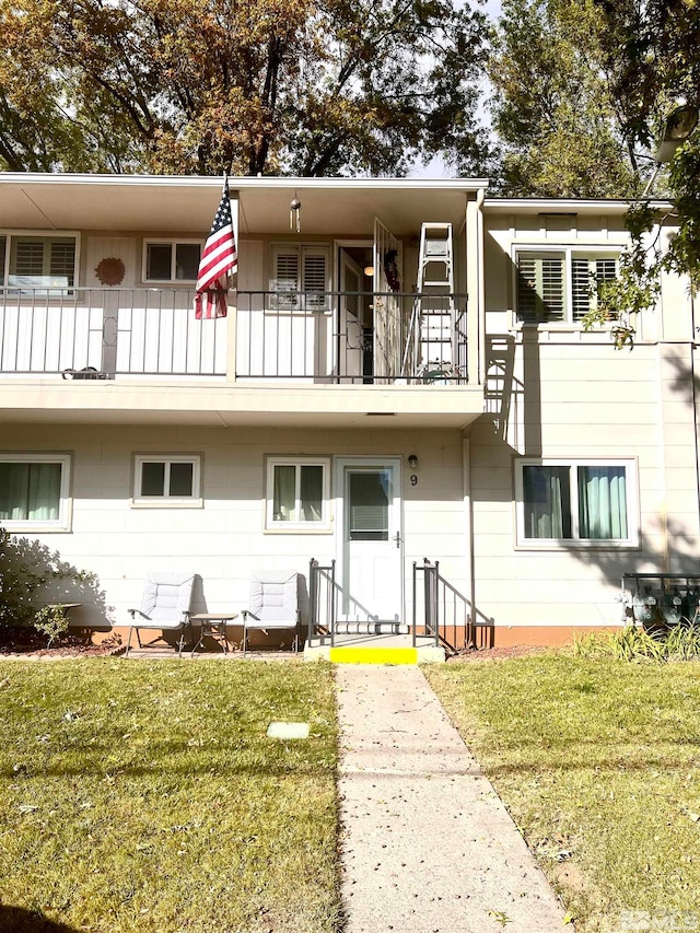 view of front of property with a balcony and a front yard