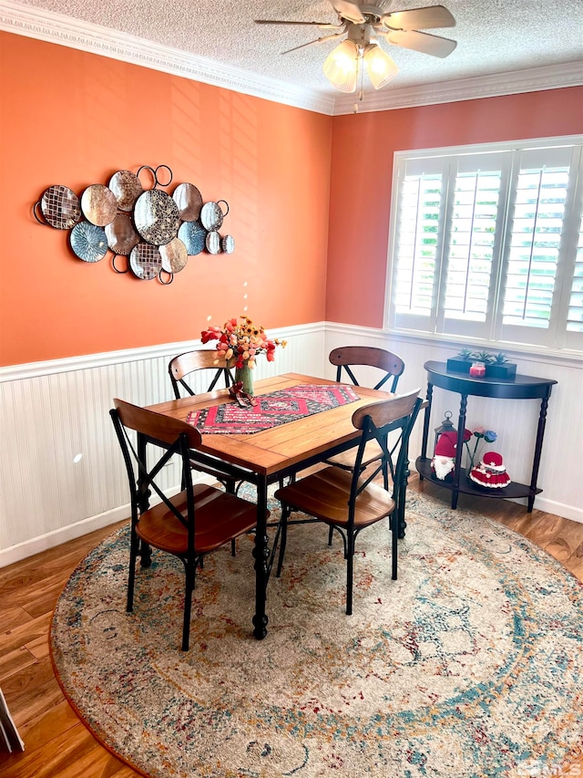 dining room with ornamental molding, a textured ceiling, and wood-type flooring