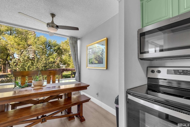 dining area with a textured ceiling, a ceiling fan, light wood finished floors, and baseboards