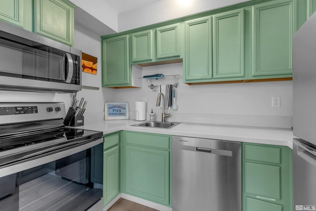 kitchen with green cabinetry, a sink, and stainless steel appliances