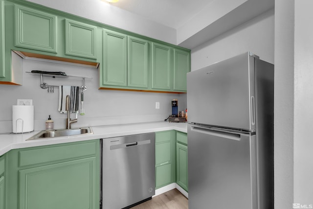 kitchen featuring sink, green cabinetry, light hardwood / wood-style flooring, and stainless steel appliances