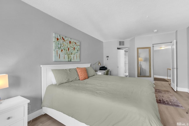 bedroom featuring a textured ceiling and light hardwood / wood-style floors