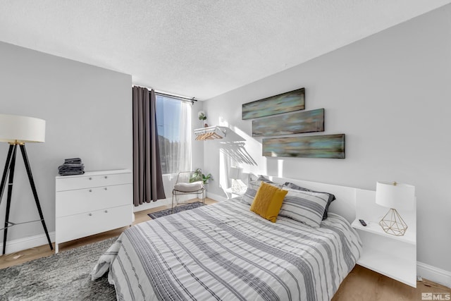 bedroom with hardwood / wood-style floors and a textured ceiling