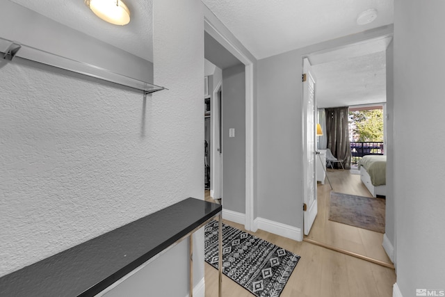 corridor featuring a textured ceiling and hardwood / wood-style floors