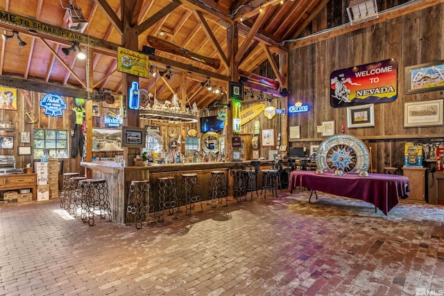 bar with pool table, high vaulted ceiling, and wood walls