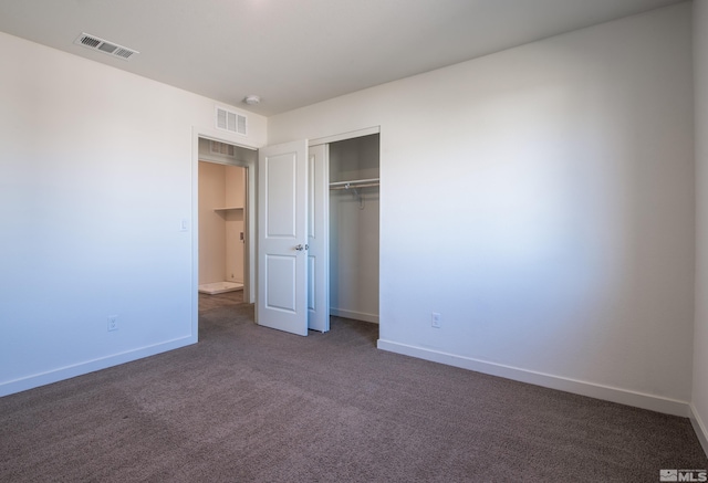 unfurnished bedroom featuring a closet and dark carpet