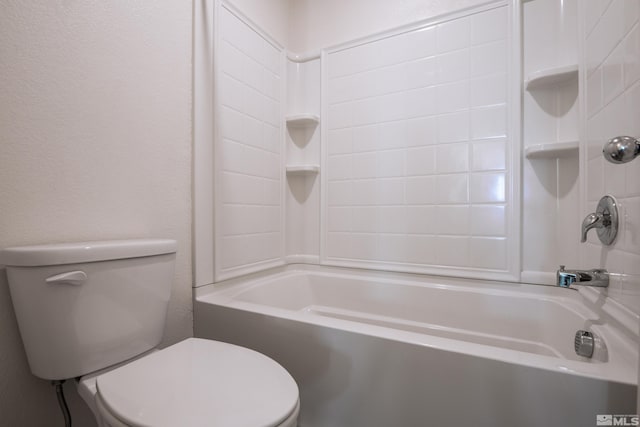 bathroom with tiled shower / bath combo and toilet