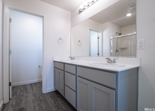 bathroom featuring vanity, toilet, hardwood / wood-style flooring, and an enclosed shower