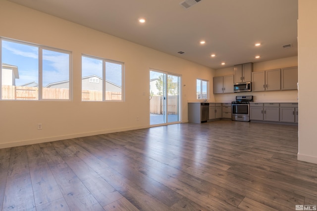 kitchen with gray cabinetry, appliances with stainless steel finishes, and dark hardwood / wood-style flooring