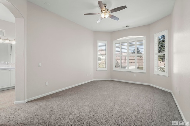 carpeted empty room with ceiling fan and sink