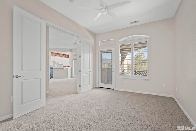 carpeted empty room featuring ceiling fan