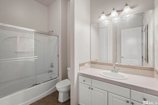 full bathroom featuring vanity, toilet, tile patterned floors, and combined bath / shower with glass door