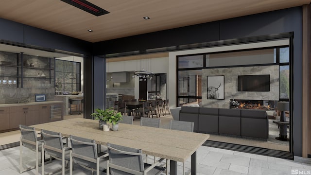 dining area with beverage cooler, a large fireplace, a healthy amount of sunlight, and wood ceiling