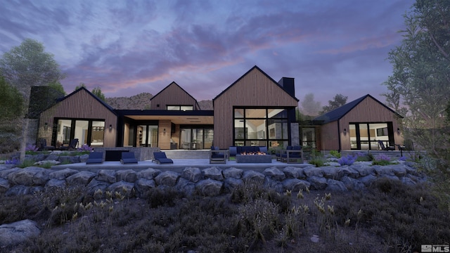 back house at dusk featuring a patio