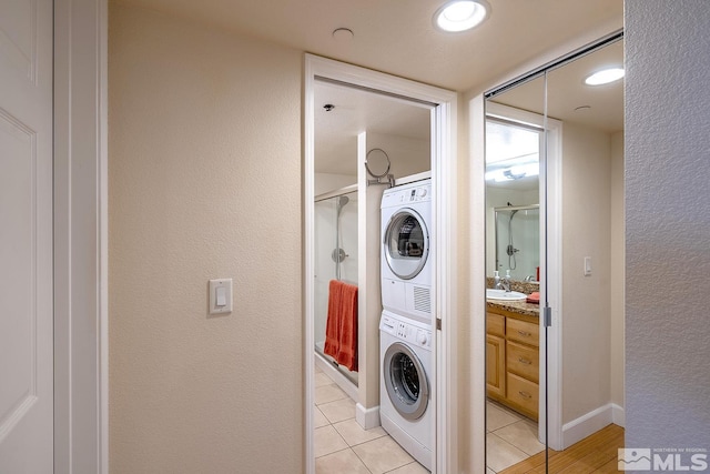 laundry area with light tile patterned flooring and stacked washer and dryer