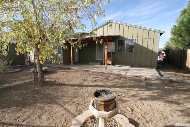 rear view of property featuring an outdoor fire pit and a patio area