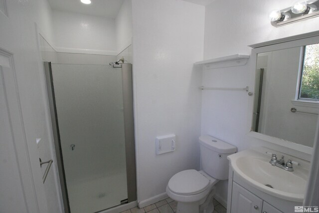 bathroom featuring vanity, toilet, tile patterned floors, and an enclosed shower