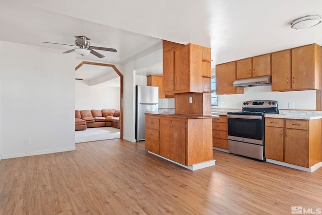 kitchen featuring a center island, appliances with stainless steel finishes, light hardwood / wood-style flooring, and ceiling fan