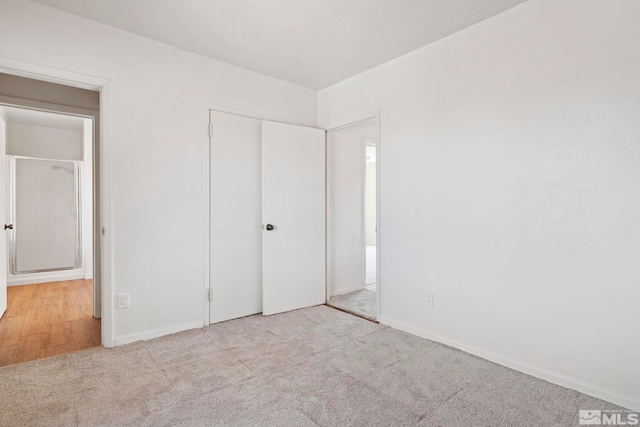 unfurnished bedroom featuring light colored carpet and a closet