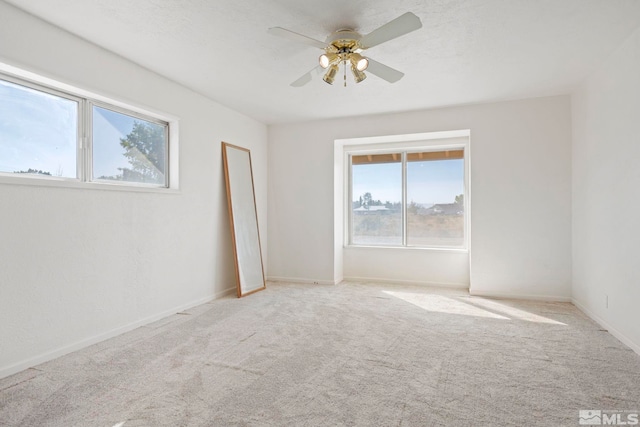 unfurnished room with light carpet, plenty of natural light, and ceiling fan