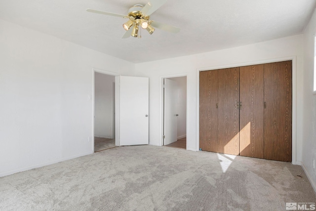 unfurnished bedroom featuring a closet, ceiling fan, and light colored carpet