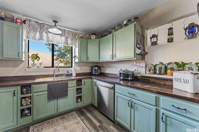 kitchen with dark hardwood / wood-style floors, wooden counters, stainless steel dishwasher, and sink