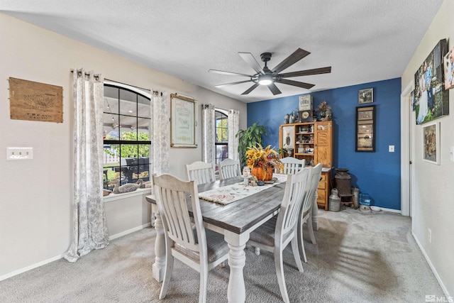 carpeted dining space featuring a textured ceiling and ceiling fan