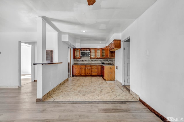 kitchen with light hardwood / wood-style floors, decorative backsplash, and sink