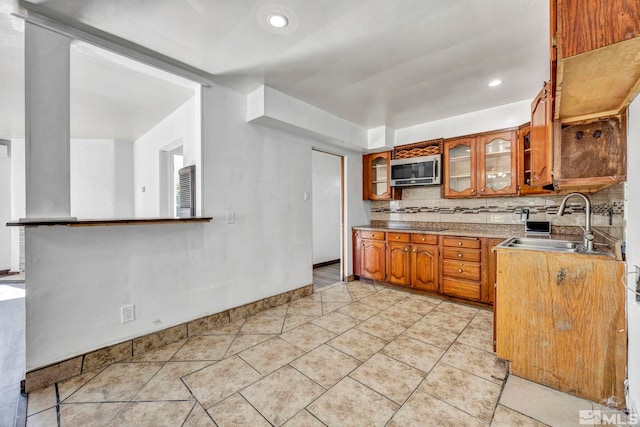 kitchen featuring decorative backsplash, sink, and light tile patterned floors