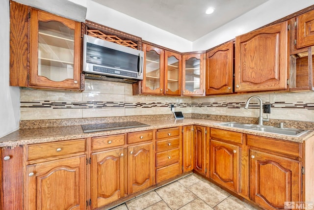 kitchen featuring light tile patterned flooring, decorative backsplash, sink, and black electric cooktop