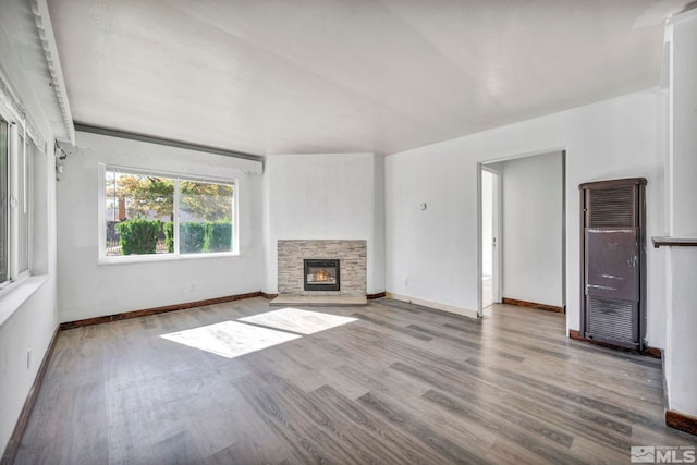 unfurnished living room featuring light wood-type flooring and a fireplace