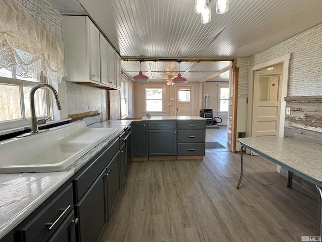 kitchen with sink, wood ceiling, white cabinetry, light hardwood / wood-style floors, and decorative light fixtures