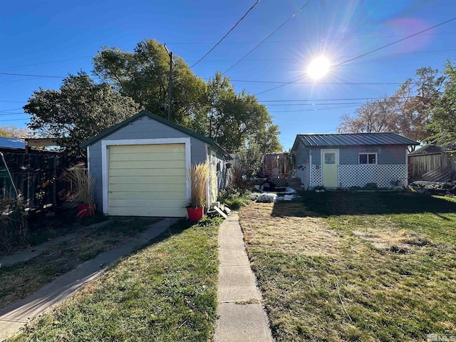 view of side of property featuring a lawn, a garage, and an outdoor structure